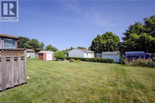 Expansive rear yard featuring a manicured lawn, established landscaping, and multiple storage sheds - 52 Queenston Crescent, Kitchener, ON - Outdoor