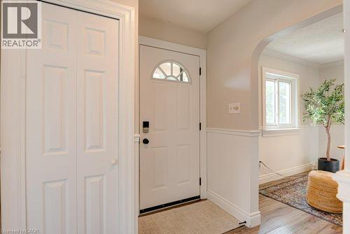 Entryway featuring a paneled door with an arched window, bifold closet doors, and wood-finish flooring - 99 Shantz Lane, Kitchener, ON - Indoor Photo Showing Other Room