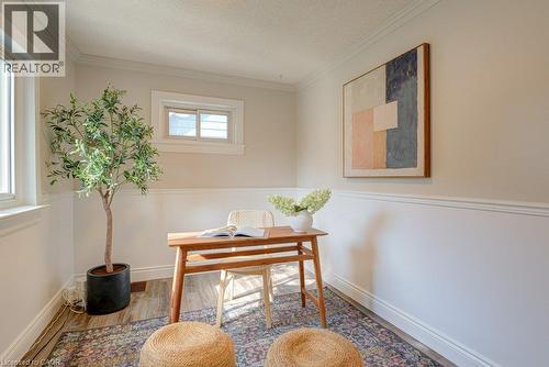Warm-toned walls with wainscoting, crown molding, and wood-finish flooring - 99 Shantz Lane, Kitchener, ON - Indoor Photo Showing Other Room