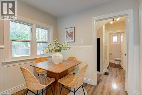 Warm wood-finish flooring, white wainscoting, and large windows - 99 Shantz Lane, Kitchener, ON - Indoor Photo Showing Dining Room