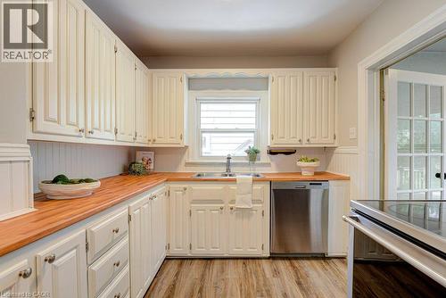 Cream-toned cabinetry with wood countertops, stainless steel dishwasher, and wood-finish flooring - 99 Shantz Lane, Kitchener, ON - Indoor Photo Showing Kitchen With Double Sink