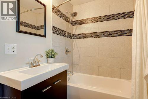 Built-in vanity with an integrated rectangular sink, chrome faucet, and dark wood-finish cabinetry - 99 Shantz Lane, Kitchener, ON - Indoor Photo Showing Bathroom