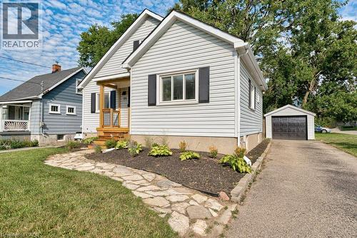White siding exterior with black window shutters and a wood-toned front porch - 99 Shantz Lane, Kitchener, ON - Outdoor