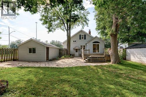 Expansive backyard with a manicured lawn, stone patio, and mature trees - 99 Shantz Lane, Kitchener, ON - Outdoor