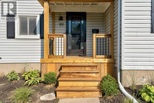 Front entry with natural wood porch and steps, black framed screen door, and white siding - 99 Shantz Lane, Kitchener, ON - Outdoor With Exterior