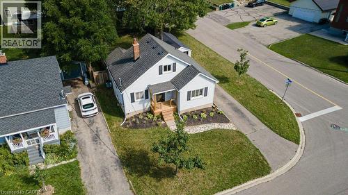 Gable roof with dark shingles, light-colored siding, dark window shutters, and a front porch with wooden railings - 99 Shantz Lane, Kitchener, ON - Outdoor