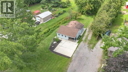 Light blue siding residence with a brown shingle roof, concrete patio, and gravel driveway - 995 Mcdowell Road E, Simcoe, ON - Outdoor