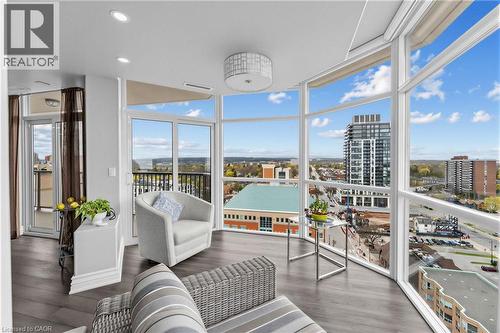 Curved wall of floor-to-ceiling windows, recessed lighting, wood-finish flooring, and a glass-paneled sliding door to a balcony - 1477 Lakeshore Road Unit# Ph 1, Burlington, ON 