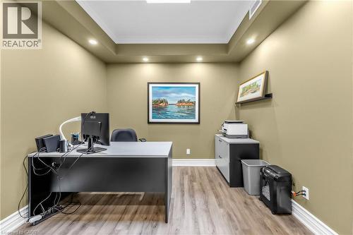 Recessed lighting illuminates a tray ceiling, enhancing the wood-finish flooring and neutral wall tones - 1477 Lakeshore Road Unit# Ph 1, Burlington, ON 