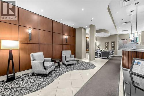 Entry area featuring wood-paneled walls with sconce lighting, tiled flooring, recessed lighting, and a reception desk - 1477 Lakeshore Road Unit# Ph 1, Burlington, ON 