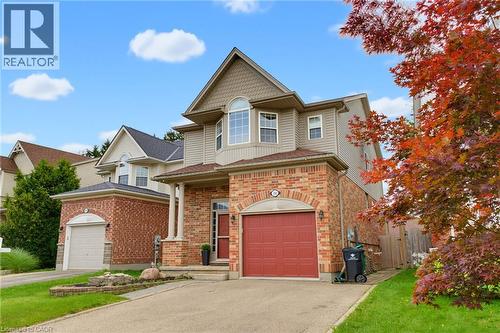 Brick and siding exterior with an arched window, dormer, and a prominent front entry with columns - 592 Little Dover Crescent, Waterloo, ON - Outdoor