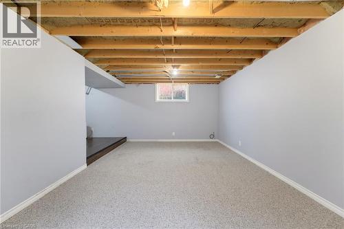 Carpeted flooring, painted walls, exposed ceiling joists, window, and wood-finish step - 592 Little Dover Crescent, Waterloo, ON - Indoor