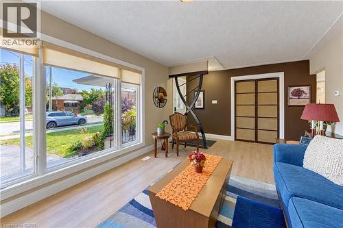 Large picture window, light wood-finish flooring, recessed entry, bi-fold doors with horizontal panels, and a painted accent wall - 87 Bond Street, Kitchener, ON 