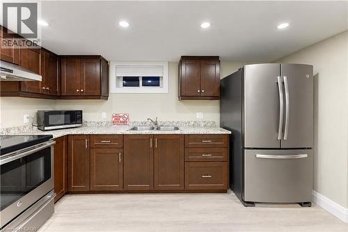 Kitchen featuring wood-finish cabinetry, granite-style countertops, wood-finish flooring, stainless steel appliances, and recessed lighting - 87 Bond Street, Kitchener, ON 