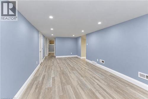 Recessed ceiling lighting, light blue wall paint, wood-finish flooring, white trim, and white louvered doors - 87 Bond Street, Kitchener, ON 