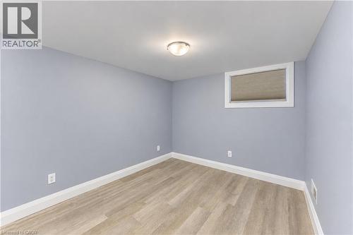 Neutral wall color, recessed window, flush-mount ceiling light, wood-finish flooring, white trim - 87 Bond Street, Kitchener, ON 
