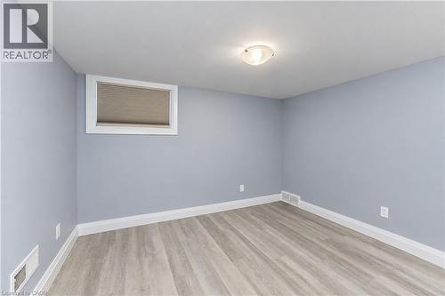 Light-toned wood-finish flooring with white baseboards - 87 Bond Street, Kitchener, ON 