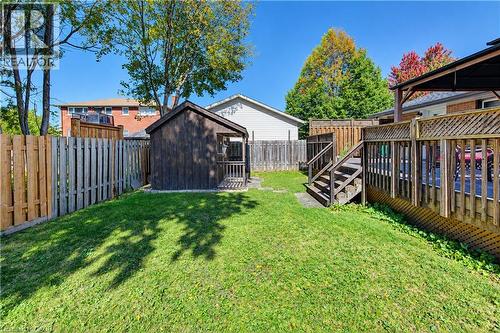 Expansive grassy area featuring a wooden shed and a multi-level wooden deck with lattice detailing - 87 Bond Street, Kitchener, ON 