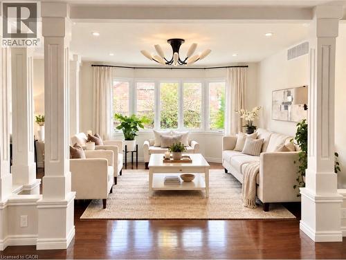 Hardwood flooring, decorative pillars, bay windows, recessed lighting, and a modern chandelier - 56 Windrush Trail, Kitchener, ON 