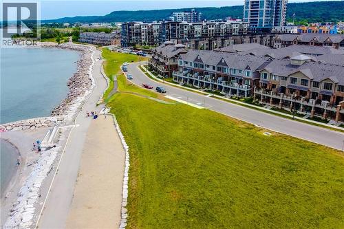 Waterfront property featuring a paved pathway, stone shoreline, and a green space - 65 Waterview Lane, Grimsby, ON 