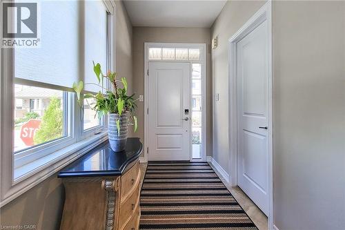 Entryway featuring a white paneled door with transom window, sidelight, and an integrated smart lock - 65 Waterview Lane, Grimsby, ON 