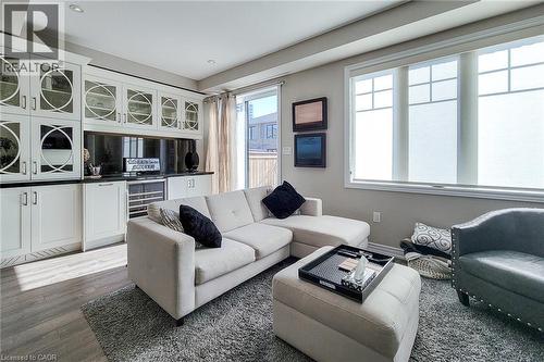 Built-in cabinetry with glass panel doors, dark countertops, recessed lighting, and wood-finish flooring - 65 Waterview Lane, Grimsby, ON 
