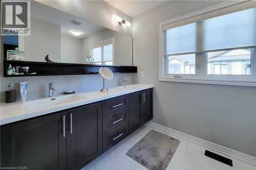 Double vanity with integrated rectangular sinks, modern faucets, and dark wood-finish cabinetry - 65 Waterview Lane, Grimsby, ON 