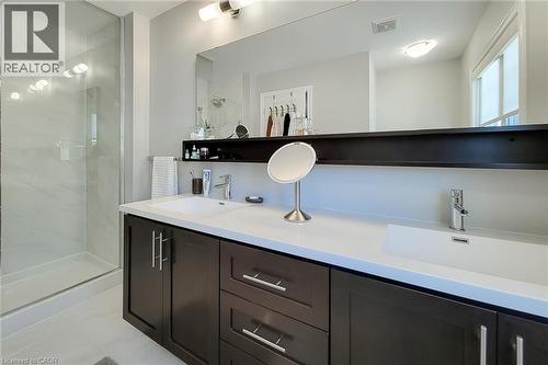 Dual vanity with white countertops, undermount sinks, and dark wood-finish cabinetry - 65 Waterview Lane, Grimsby, ON 