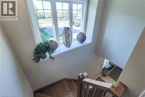 Staircase featuring wood-finish treads and risers, wood newel posts, and wood handrails - 65 Waterview Lane, Grimsby, ON 