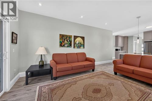 Recessed ceiling lighting, wood-finish flooring, sliding glass door, and a kitchen with stainless steel appliances - 41 Eleanor Avenue, Hamilton, ON 
