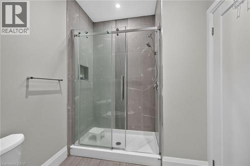 Enclosed shower with sliding glass doors, large format wall tiling, and a built-in shower niche - 41 Eleanor Avenue, Hamilton, ON 