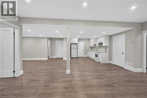 Open-concept living area featuring wood-finish flooring, recessed lighting, and a kitchen with white cabinetry - 41 Eleanor Avenue, Hamilton, ON 