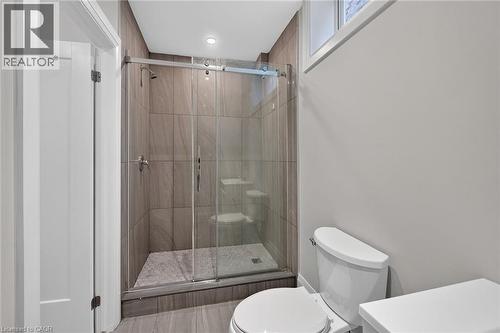 Walk-in shower with clear glass enclosure, tiled walls, and a pebbled floor - 41 Eleanor Avenue, Hamilton, ON 