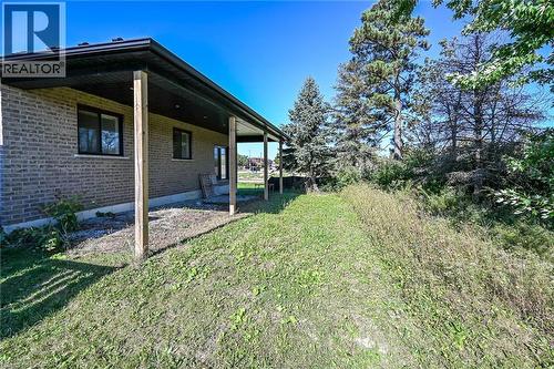 Covered rear patio extending along the brick exterior - 41 Eleanor Avenue, Hamilton, ON 