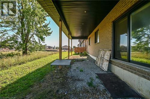 Brick exterior with multiple windows and a covered patio area featuring support columns - 41 Eleanor Avenue, Hamilton, ON 