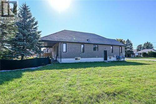 Brick exterior with contrasting dark-framed windows, a covered deck, and a dark shingle roof - 41 Eleanor Avenue, Hamilton, ON 