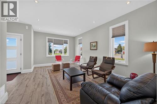 Recessed ceiling lighting, wood-finish flooring, white trim, multiple windows with blinds, and a paneled entry door - 41 Eleanor Avenue, Hamilton, ON 