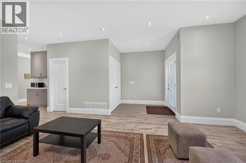 Recessed lighting, light gray painted walls, wood-finish flooring, white trim, and a white entry door with frosted glass panels - 41 Eleanor Avenue, Hamilton, ON 