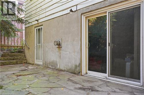 Stonework patio with a sliding glass door entry and an additional side entry door - 12 Hill Street, Kitchener, ON 