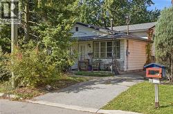 White siding exterior with a dark-shingled roof and covered front porch - 
