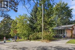 Single-story residence with light-colored siding, a covered front porch, and a paved driveway - 