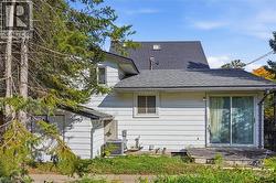 White horizontal siding exterior with a sliding glass door and a small deck - 