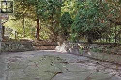 Stone patio with flagstone paving and stacked stone retaining walls - 