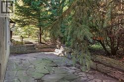 Flagstone patio with a stacked stone retaining wall - 