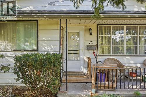White horizontal siding exterior with a front entry door and a decorative screen door - 12 Hill Street, Kitchener, ON 