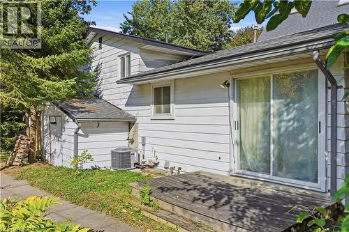 Exterior featuring white siding, a wooden deck, and a sliding glass door - 12 Hill Street, Kitchener, ON 