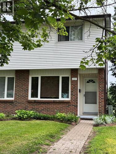 Brick and siding exterior with a paver walkway, mature trees, and landscaping - 227 Fergus Avenue, Kitchener, ON 