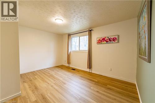 Neutral wall tones, wood-finish flooring, and natural light from a double-pane sliding window - 227 Fergus Avenue, Kitchener, ON 