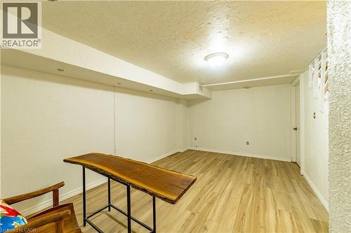 Neutral interior room featuring wood-finish flooring, recessed lighting, a textured ceiling, and a clean-lined soffit - 227 Fergus Avenue, Kitchener, ON 