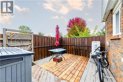 Outdoor deck featuring wood-finish decking, brick exterior wall, and privacy wood fencing - 227 Fergus Avenue, Kitchener, ON 
